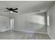 An open-concept living room with gray vinyl floors, a ceiling fan and back door at 4885 Maristone Landing Way, Cumming, GA 30040