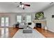 Cozy living room with fireplace, ceiling fan, plush seating, and lots of natural light at 4885 Maristone Landing Way, Cumming, GA 30040