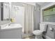 Clean and modern bathroom with a white vanity, toilet, and shower with decorative curtain at 677 Holmes Nw St, Atlanta, GA 30318