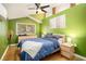Bright bedroom with green accent wall, ceiling fan, and natural light from the window at 677 Holmes Nw St, Atlanta, GA 30318