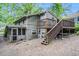 Rear exterior view with a deck, stairs, and screened porch, surrounded by a gravel yard at 677 Holmes Nw St, Atlanta, GA 30318