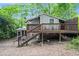 Rear exterior showcasing the deck and stairs of the home in a wooded backyard at 677 Holmes Nw St, Atlanta, GA 30318