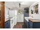 Basement kitchen featuring white appliances, subway tile backsplash, and deep blue cabinets at 677 Holmes Nw St, Atlanta, GA 30318