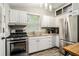 Modern kitchen with stainless steel appliances, white cabinets, and ample counter space at 677 Holmes Nw St, Atlanta, GA 30318