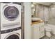 Well-appointed bathroom with stackable washer and dryer, stylish vanity and tiled floor at 157 Maribeau Nw Sq, Atlanta, GA 30327