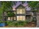 Charming two-story home with multiple windows and balconies surrounded by mature trees and lush landscaping at 2105 Country Park Se Dr, Smyrna, GA 30080