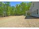 Sloping backyard with a covered patio, offering ample space and a connection with nature at 2749 Porches Ln, Dacula, GA 30019