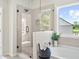 Bright bathroom featuring soaking tub, glass shower, and views of the beautiful exterior landscape at 2749 Porches Ln, Dacula, GA 30019