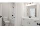 Bright bathroom featuring white cabinets, a large mirror, a toilet, and a tub with a shower at 2749 Porches Ln, Dacula, GA 30019