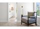 Comfortable bedroom featuring a cozy armchair, stylish lighting, and a glimpse into the en-suite bathroom at 2749 Porches Ln, Dacula, GA 30019