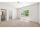 A spacious bedroom with neutral walls, carpeted floors, a large window, and ensuite bathroom at 2749 Porches Ln, Dacula, GA 30019