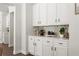 A butler's pantry is displayed with white cabinets and drawers with dark hardware at 2749 Porches Ln, Dacula, GA 30019