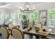 Bright dining room with a long wood table, contemporary light fixtures and hardwood floors at 2749 Porches Ln, Dacula, GA 30019