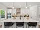 Modern kitchen boasts a spacious island with seating, stylish pendant lighting, and stainless steel appliances at 2749 Porches Ln, Dacula, GA 30019