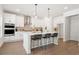 Bright kitchen features a large island, stainless steel appliances, pendant lights and hardwood floors at 2749 Porches Ln, Dacula, GA 30019