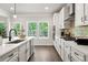 A modern kitchen with white cabinets, stainless steel appliances, and an island with hardwood floors at 2749 Porches Ln, Dacula, GA 30019