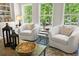 Cozy sitting area with armchairs, natural light from windows, and stylish decor on a wooden coffee table at 2749 Porches Ln, Dacula, GA 30019