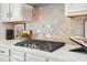 Close up of a modern stovetop with designer tile backsplash at 2749 Porches Ln, Dacula, GA 30019