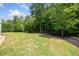 Expansive backyard features lush green lawn and mature trees, providing privacy and a serene outdoor space at 390 Scott Farm Dr, Powder Springs, GA 30127