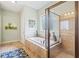 Bright bathroom with a luxurious soaking tub, decorative tile surround, and a separate shower, offering a spa-like experience at 390 Scott Farm Dr, Powder Springs, GA 30127