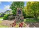 Stone sign marks the entrance to Scott Farm, framed by manicured landscaping and lush greenery at 390 Scott Farm Dr, Powder Springs, GA 30127