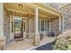 Charming front porch with rocking chairs, stone accents, and a welcoming entrance at 390 Scott Farm Dr, Powder Springs, GA 30127