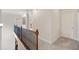 Upstairs hallway with hardwood railing and neutral carpeting leads to bedrooms and other living spaces in the home at 390 Scott Farm Dr, Powder Springs, GA 30127
