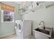 Functional laundry room featuring modern washer and dryer, utility sink, and storage shelves at 390 Scott Farm Dr, Powder Springs, GA 30127