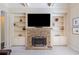 Living room highlighting a stone fireplace, custom shelving, and a cozy seating area at 390 Scott Farm Dr, Powder Springs, GA 30127