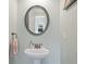Charming powder room features a pedestal sink, decorative mirror, and neutral paint at 390 Scott Farm Dr, Powder Springs, GA 30127