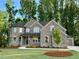 Stunning two-story brick home with a manicured lawn and lush trees at 4050 Sierra Vista Cir, Cumming, GA 30040