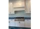 Close-up of the kitchen with white cabinets, herringbone backsplash, and range at 4050 Sierra Vista Cir, Cumming, GA 30040