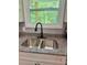 Stainless steel kitchen sink with black faucet, set into granite countertops at 201 Deerfield Ln, Carrollton, GA 30116
