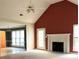 Bright living room featuring vaulted ceilings, a fan, fireplace, carpeted floor, and a view of the kitchen at 300 Gaelic Way, Tyrone, GA 30290