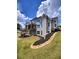Expansive backyard view showing the house's exterior, a lush lawn, and terraced landscaping at 312 Archway Ln, Peachtree City, GA 30269