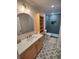 Modern bathroom with stylish vanity, beautiful shower with green tile, and patterned floor at 312 Archway Ln, Peachtree City, GA 30269