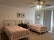 Charming bedroom featuring two twin beds, floral wallpaper, and ample natural light at 312 Archway Ln, Peachtree City, GA 30269