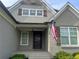 Close-up of a home's covered front entrance with an American flag waving by the front door at 312 Archway Ln, Peachtree City, GA 30269