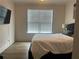 Modern bedroom featuring hardwood floors, a comfortable bed, and a large window for natural light at 312 Archway Ln, Peachtree City, GA 30269