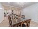 Dining room with wood table set for six, modern chandelier, and open-concept kitchen at 4367 Cedar Wood Sw Dr, Lilburn, GA 30047