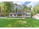 Inviting two-story white brick home featuring black shutters and a meticulously maintained front lawn at 4367 Cedar Wood Sw Dr, Lilburn, GA 30047