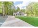 Long driveway leads up to a two-story house on a lush lot with mature trees and an attached garage at 4367 Cedar Wood Sw Dr, Lilburn, GA 30047
