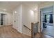 Hallway with wood floors leading to bedrooms and bathrooms with a modern staircase at 4367 Cedar Wood Sw Dr, Lilburn, GA 30047