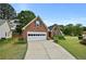 Quaint brick home with an attached garage and driveway, surrounded by lush green lawns at 4730 Fairway View Ct, Duluth, GA 30096