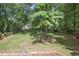 Beautiful back yard with mature trees and lush green grass with a partial view of the home at 946 Cornwall Sw Ct, Marietta, GA 30064