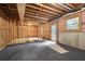 Unfinished basement featuring carpet, exposed framing, and a door to outside at 946 Cornwall Sw Ct, Marietta, GA 30064
