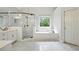 Bright bathroom featuring white tile, a frameless shower, and a separate soaking tub at 946 Cornwall Sw Ct, Marietta, GA 30064