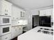 Kitchen showcasing white cabinetry, stainless steel appliances, hardwood floors, and under cabinet lighting at 946 Cornwall Sw Ct, Marietta, GA 30064
