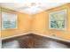 Bedroom features hardwood floors, two windows, and a ceiling fan at 1094 Seville Dr, Clarkston, GA 30021