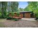 Back of house with brick exterior, deck, patio, and mature landscaping at 1094 Seville Dr, Clarkston, GA 30021